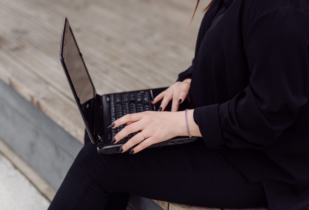 young brown hair woman with laptop and smart phone computer sitting on wood floor